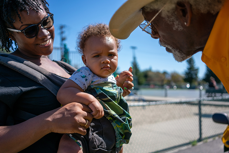 Oakland Black Cowboy greeting baby and it's mother at Block Party