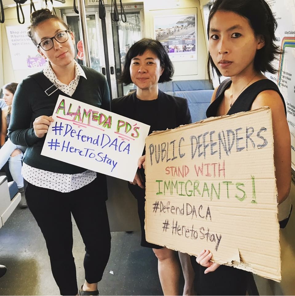 Immigration Attorneys hold #DefendDACA signs on BART train